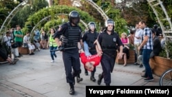 Mikhail Bykanov is carried away by riot police amid protests in Moscow on July 27.