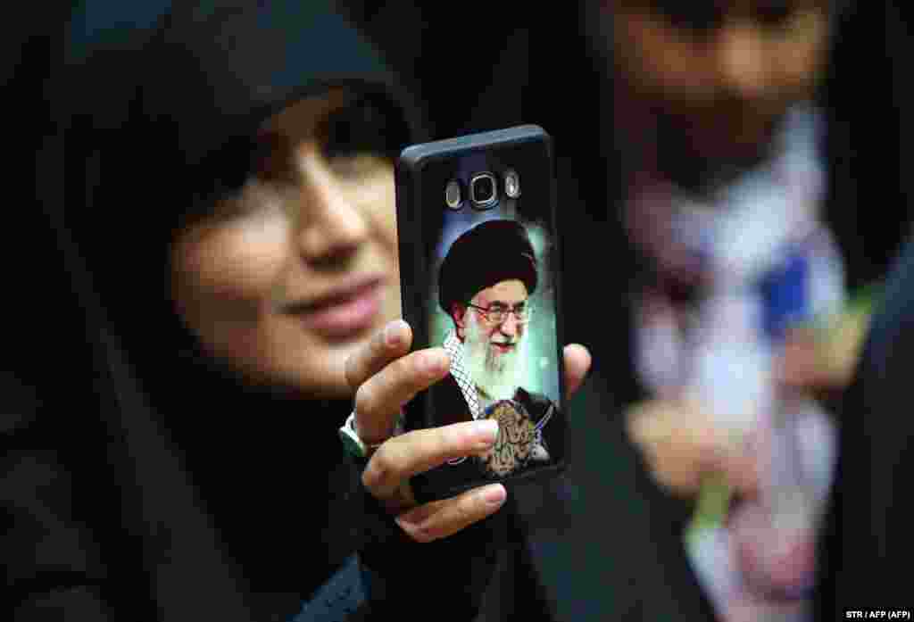 An Iranian woman shows her phone cover depicting Iran&#39;s Supreme Leader Ayatollah Ali Khamenei as she attends a rally to support head scarves in Tehran. (AFP)