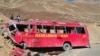 FILE: People stand beside the wreckage of a passenger bus at the scene of its accident near Chilas in Gilgit-Baltistan in September 2019.