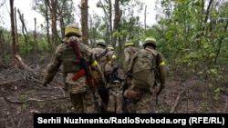 Українські військовій виносять загиблого бійця ЗСУ із поля бою після штурмових дій під Бахмутом, Донецька область, травень 2023 рік автор Сергій Нужненко