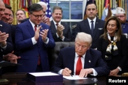 Predsjedavajući Predstavničkog doma SAD-a Mike Johnson (R-LA) aplaudira dok predsjednik SAD-a Donald Trump potpisuje zakon o finansiranju kojim se okončava blokada rada američke vlade, u Bijeloj kući u Washingtonu, 12. novembra 2025.