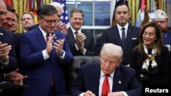 رئیس جمهور دونالد ترمپ حین امضای لایحۀ تامین بودجه برای پایان تعطیلی دولت ایالات متحده