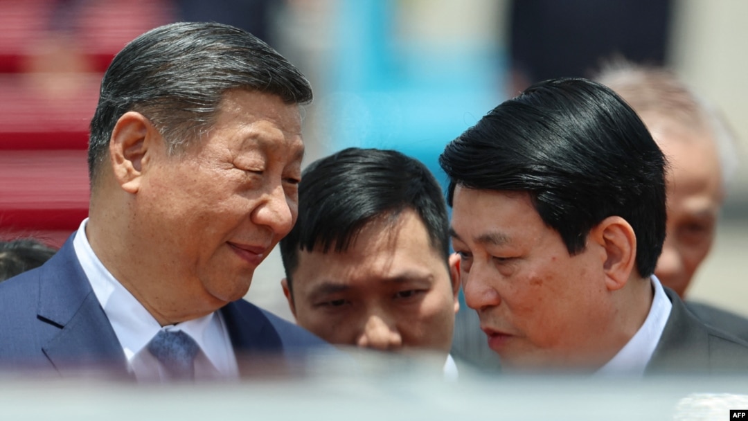 Președintele Chinei, Xi Jinping (s), discută cu președintele Vietnamului, Luong Cuong (d), la începutul vizitei de stat pe care o face la Hanoi, pe 14 aprilie 2025.