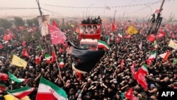 Mourners gather along the route of the convoy carrying the coffins of Iran's Supreme Leader Ayatollah Ali Khamenei and members of his family during a funeral procession in Qom on July 7.