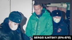 Russian opposition leader Aleksei Navalny is escorted out of a police station in Khimki, outside Moscow, on January 18. 