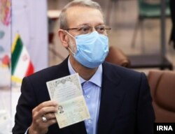 Ali Larijani poses for photographers while registering his candidacy for president.