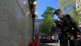 RUSSIA -- A serviceman lays flowers at a makeshift memorial outside the representative office of the Republic of Tatarstan to commemorate victims of the deadly shooting in Kazan School Number 175, in Moscow, Russia May 11, 2021.