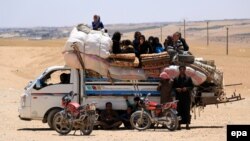 Syrians who fled the Islamic State (IS) group stronghold of Raqqa ride with their belongings on a truck in an area near the village of Balaban, south of Jarablus, on June 8.