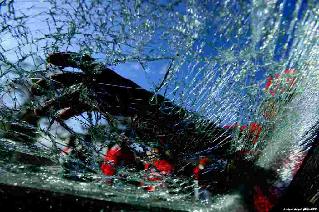 A Pakistani security official inspects the damaged wind screen of a vehicle at the scene of a bomb attack that targeted a senior police officer in Peshawar on November 24. (epa-EFA/Arshad Arbab)