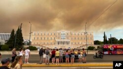 Piața Syntagma, din centrul Atenei, duminică - în fundal, pătura de fum generată de incendiile vegetale.