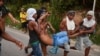 Opposition demonstrators carry an injured protester on the Brazilian side of the border between Venezuela and Pacaraima, Roraima state, Brazil, where clashes erupted amid efforts to take aid into the crisis-hit country, on February 23, 2019. 