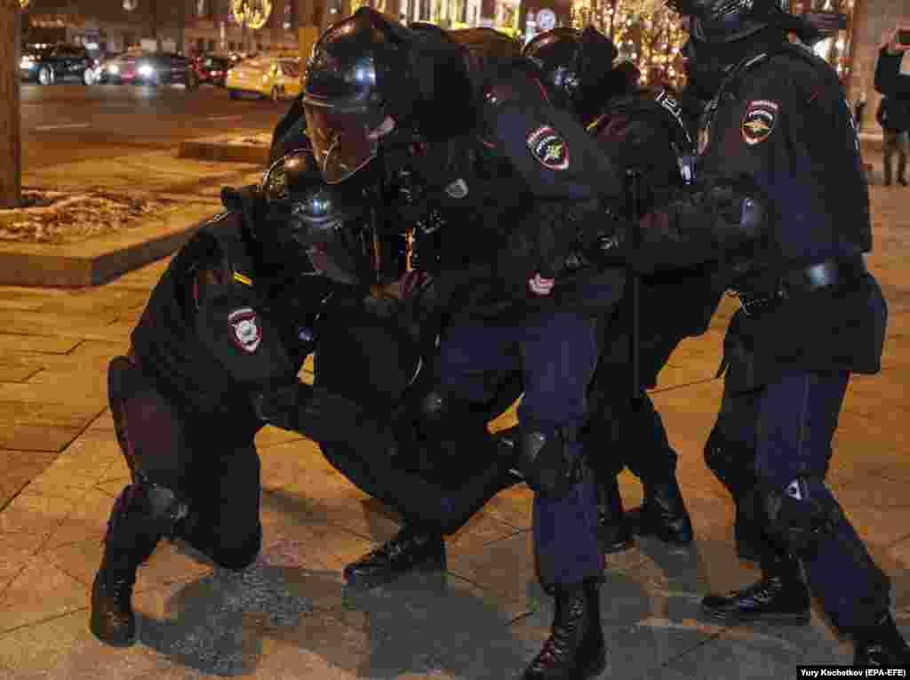 Riot police violently detain a Navalny supporter in Moscow.