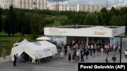 People wait in line at a vaccination center in a park in Moscow's outskirts on July 1.