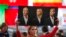 Një gazetare në Rusi mban portretet e presidentit rus, Vladimir Putin, lideres së Frontit Kombëtar në Francë, Marine Le Pen, dhe presidentit të SHBA-së, Donald Trump.