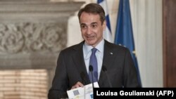 GREECE -- Greek Prime Minister Kyriakos Mitsotakis shows the proposed EU digital Covid Certificate during a joint statement to the press with the European Council President after their meeting in Athens, May 28, 2021