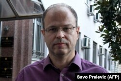Jovo Martinovic montenegrói oknyomozó újságíró sokat foglalkozott a környékbeli szervezett bűnözésssel. A helyi ügyészek viszont őt vádolták meg kábítószercsempészettel, tavaly másfél év börtönre is ítélték, de ő a bizonyítékok hiányára hivatkozva fellebbezett.A kép egy podgoricai bíróság előtt készült 2020. október 8-án. A CPJ egyébként nem számolta bele a listájába