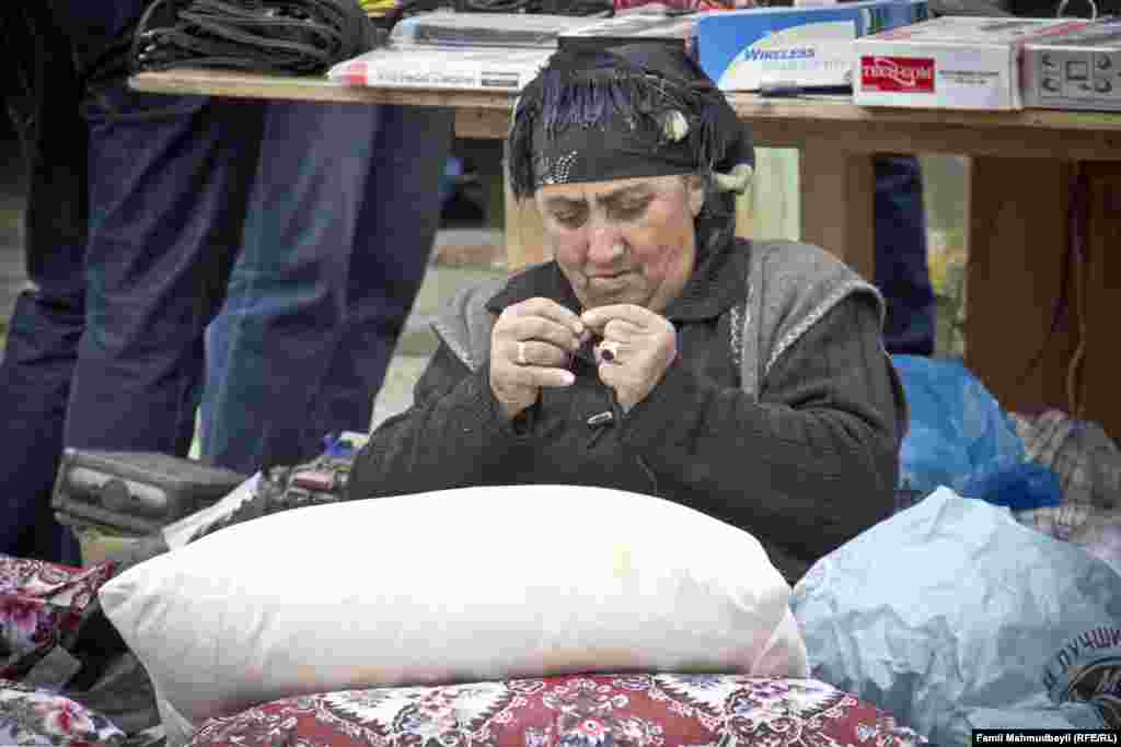 "Mən yorğan-döşək sırıyıb satıram", danışa-danışa nənə iynə saplayır.&nbsp;"Elə də olur ki müştəri səhər gəlib sifarişini verir. Məsələn, balaca döşəkcələr, gəlib o biri bazar aparır. Amma ay bala, artıq yaşlanmışam, gözlərim yaxşı görmür ki, iynəni saplayım".