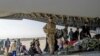 Brit és kettős állampolgárok szállnak fel egy katonai gépre a kabuli repülőtéren 2021. augusztus 16-án