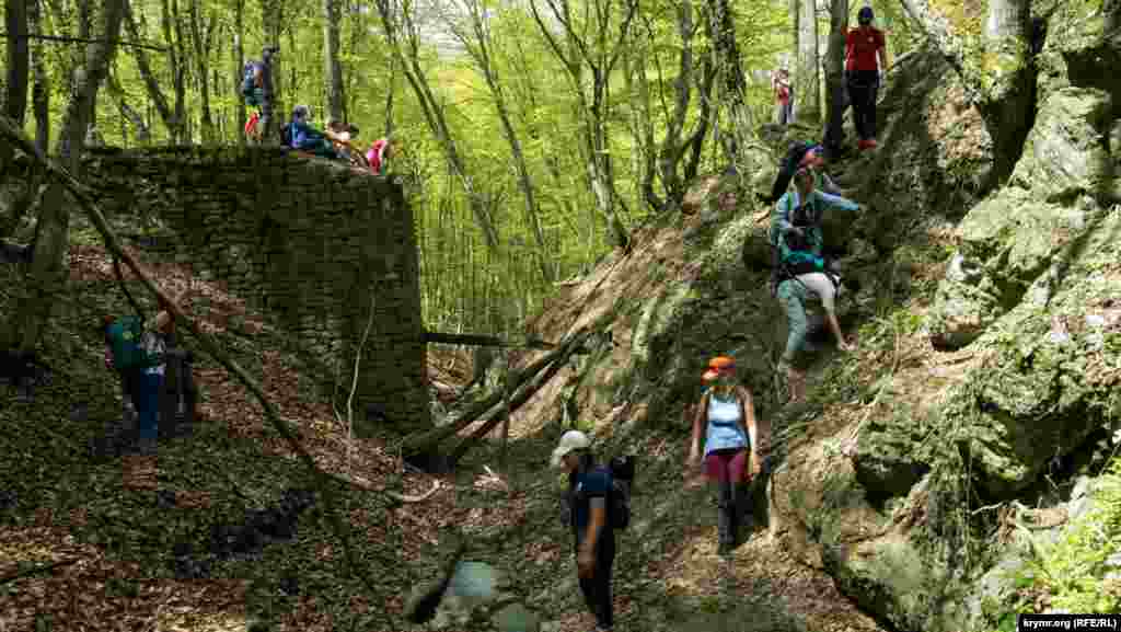 Туристы у разрушенного деревянного моста через горную речку