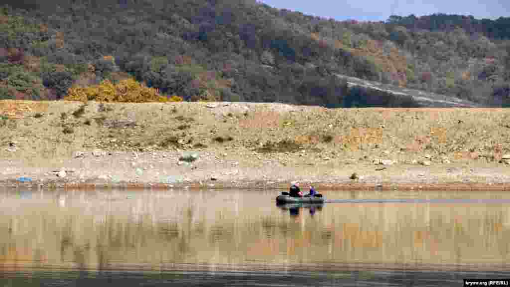 Отдыхающие на резиновом плоту плавают по озеру