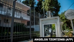 A photo taken on September 17 shows a broken window in a police booth in front of the Iranian Embassy in Athens.