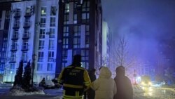 Люди, стоять під своїм будинком, у який вночі влучив російський дрон. Буча, Київщина. 28 січня 2026 року 