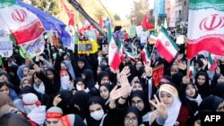 Iranian women wave their national flag outside the former US embassy inTehran, November 3, 2016