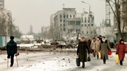 Жители Грозного на разрушенных улицах города в феврале 1996 года, через два с лишним года после начала войны в Чечне