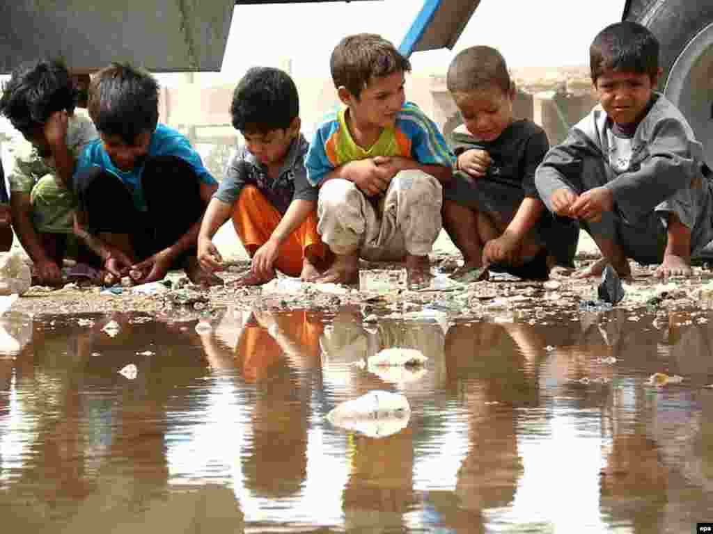 Iraq -- Iraqi displaced children gathered around pool of water at their refugee camp in Al-Najaf, 31May2007 - 31 травня 2007, Аль Наджаф, Ірак: діти - біженці навколо калабані в таборі іракських біженців.