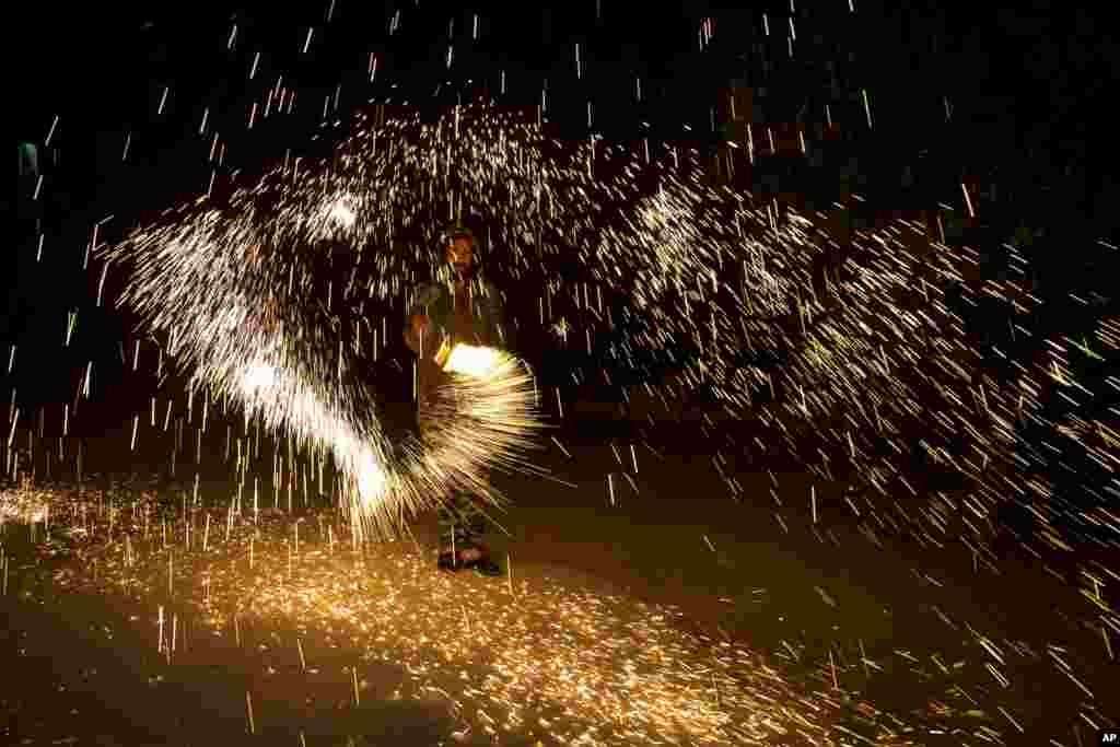 Палестинець грається з бенгальськими вогнями під час святкування початку Рамадана в місті Наблусі, Західний берег Йордану, 23 квітня