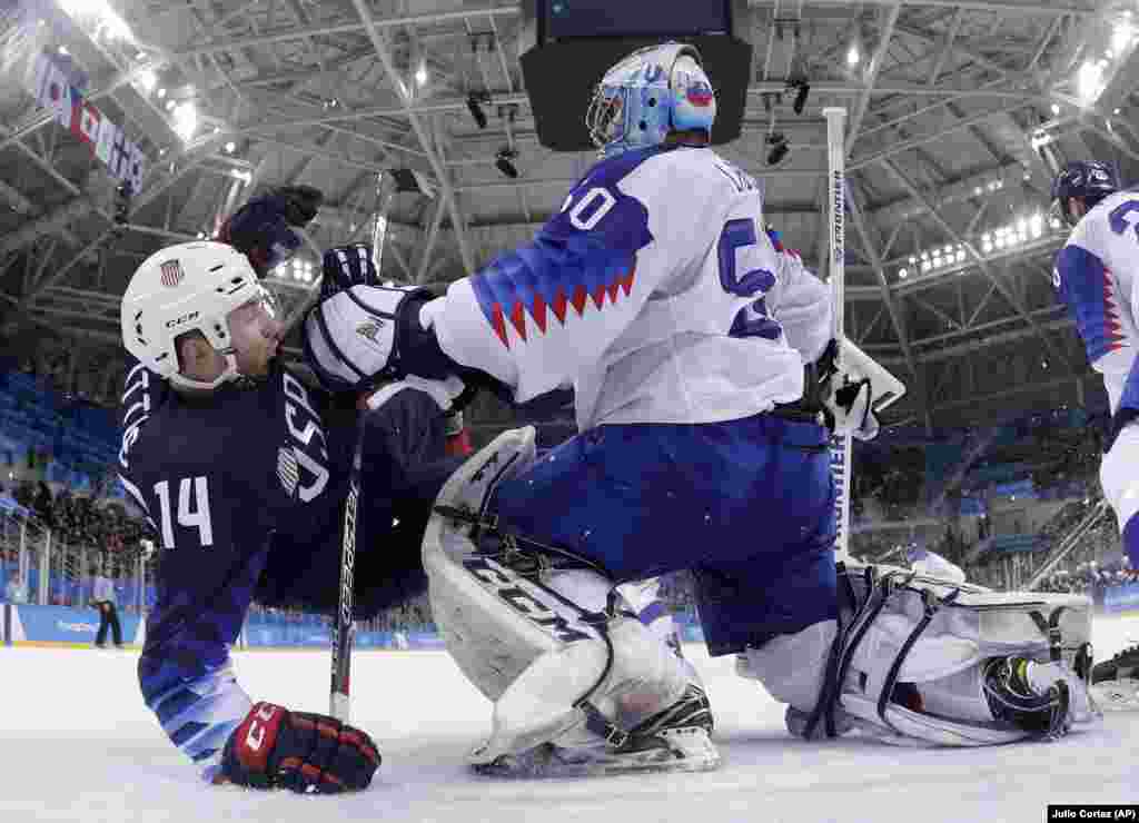 Хокей на льоду: воротар Ян Лацо зі Словаччини штовхає американця Брока Літла під час третього кваліфікаційного раунду чоловічого хокею на зимових Олімпійських іграх. Команда США виграла в Словаччини з рахунком 5:1