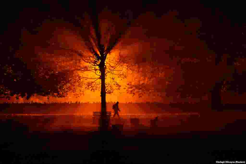 A man walks through a park during a cold, foggy night in Athboy, Ireland. (Reuters/Clodagh Kilcoyne)