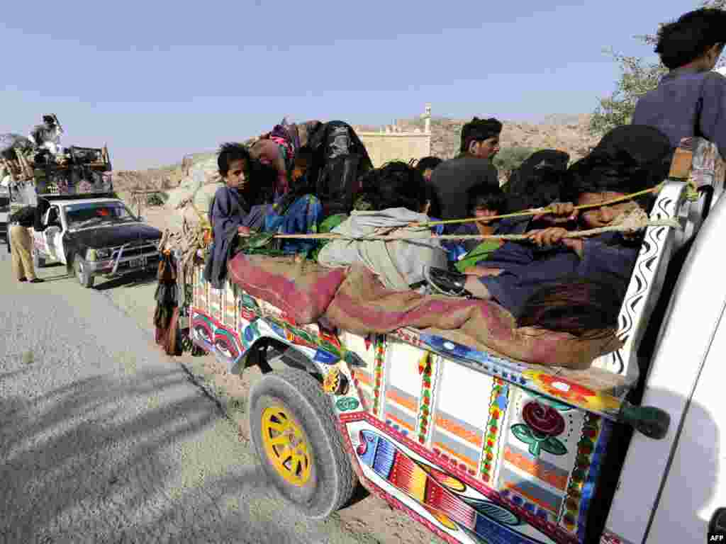 Pakistan -- Displaced families flee from military operations against Taliban militants in South Waziristan, 19Oct2009 - PAKISTAN, Dera Ismail Khan : Internally displaced Pakistani families, fleeing from military operations against Taliban militants in South Waziristan, transport their belongings through a security post in Dera Ismail Khan on October 19, 2009.