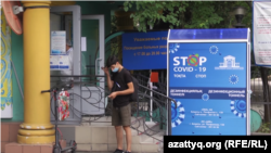 Человек в маске у входа в больницу в Алматы. Июль 2020 года.