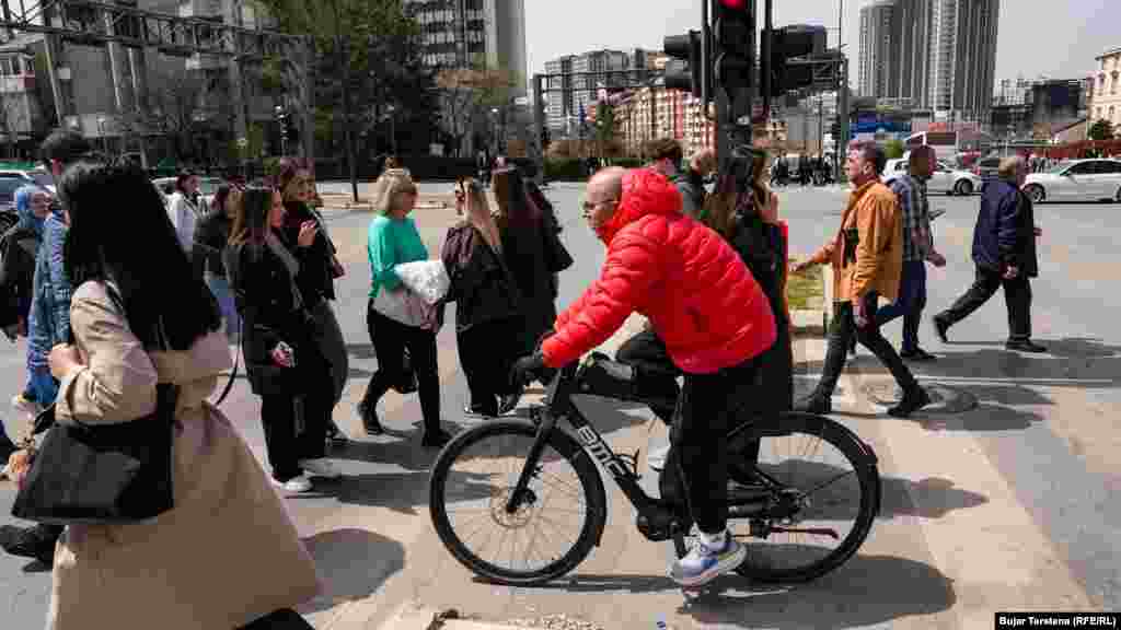 Një qytetar duke kaluar zebrat me biçikletën e tij. Transporti me biçikleta, trotinetë elektrikë dhe vetura elektrike ndihmon në ruajtjen e mjedisit. Ndërkaq, ngasja e biçikletave po ashtu ofron përfitime shëndetësore.