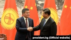 Қырғызстан президенті Сооронбай Жээнбеков пен Қытай басшысы Си Цзиньпин қол алысып тұр. Пекин, 6 маусым 2018 жыл.