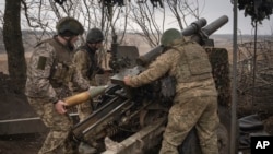 Українські військові ведуть вогонь з гаубиці М101 на позиціях поблизу Авдіївки, Донецька область, Україна, 22 березня 2024 року