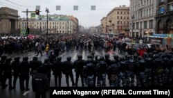 Russian law enforcement officers block a road as protesters march during a rally in support of jailed Russian opposition leader Alexei Navalny in St. Petersburg on January 23. 