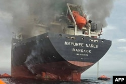 A photo released by the Royal Thai Navy shows smoke rising from the Thai-flagged bulk carrier Mayuree Naree near the Strait of Hormuz after an attack on March 11.