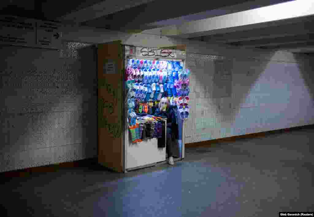 A woman selling flip-flops waits for customers at an underground walkway in Kyiv. (Reuters/Gleb Garanich)