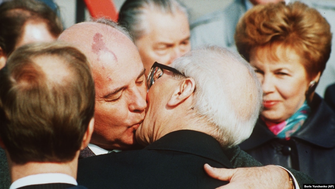 Mihail Gorbaciov îl îmbrățișează pe liderul est-german Erich Honecker la sosirea pe aeroportul Schoenefeld în Berlinul de răsărit pe 6 octombrie 1989. (AP-Photo/Boris Yurchenko)