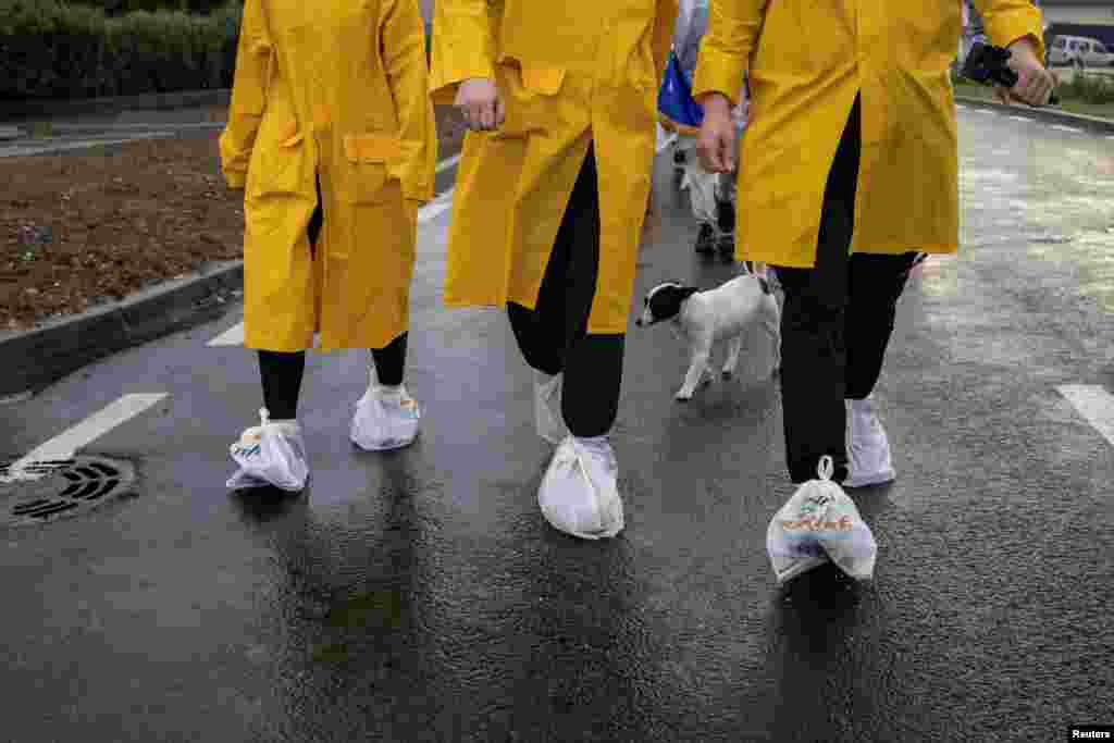 A tragédia helyszíne fele menetelnek a tiltakozó diákok Novi Pazarból az évfordulóhoz közeledve, az eső ellen esőkabátban és a cipőikre rögzített műanyagzacskókkal védekezve október 26-án