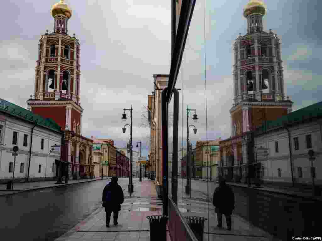 A woman walks on a deserted street past the Vysoko-Petrovsky Monastery in downtown Moscow. (AFP/Dimitar Dilkoff)