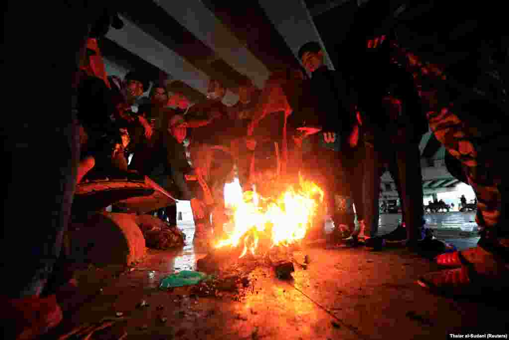 Iraqi demonstrators warm themselves during ongoing anti-government protests in Baghdad. (Reuters/Thaier al-Sundani)