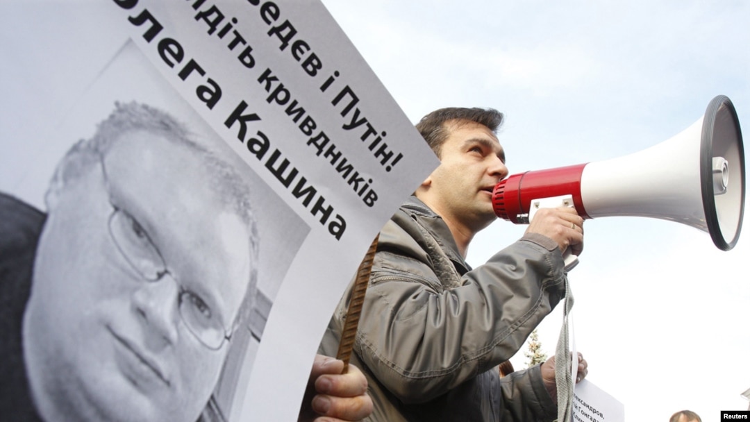 Ukrainian protesters hold a portrait of Russian journalist Oleg Kashin during a protest. 