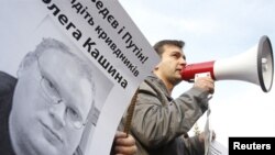 Ukrainian protesters hold a portrait of Russian journalist Oleg Kashin during a protest. 