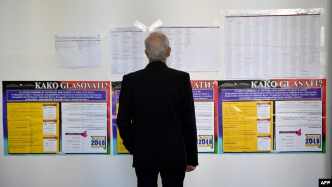 Čovjek gleda kandidatske liste na jednom od glasačkih mjesta za opšte izbore u BiH, Sarajevo, oktobar 2018.