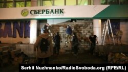 Ukrainian nationalists brick up a branch of the Russian-owned Sberbank in Kyiv on March 13. 