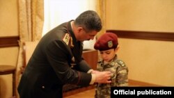 Закир Гасанов вручает медаль "Золотая звезда" на грудь 7-летнего сына героя