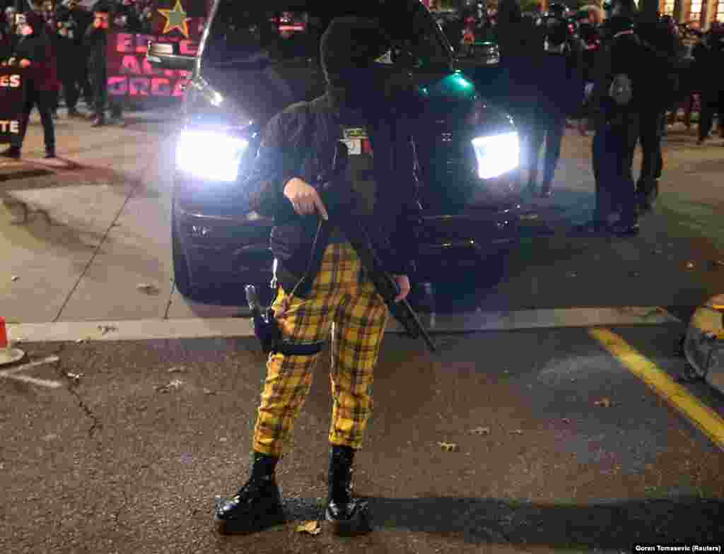 Участница протестов в Портленде с оружием в руках.